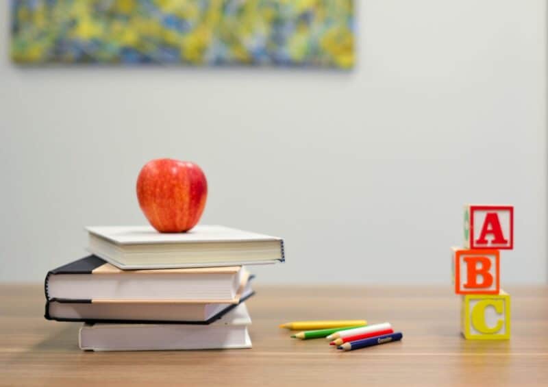 Books with an apple on a desk