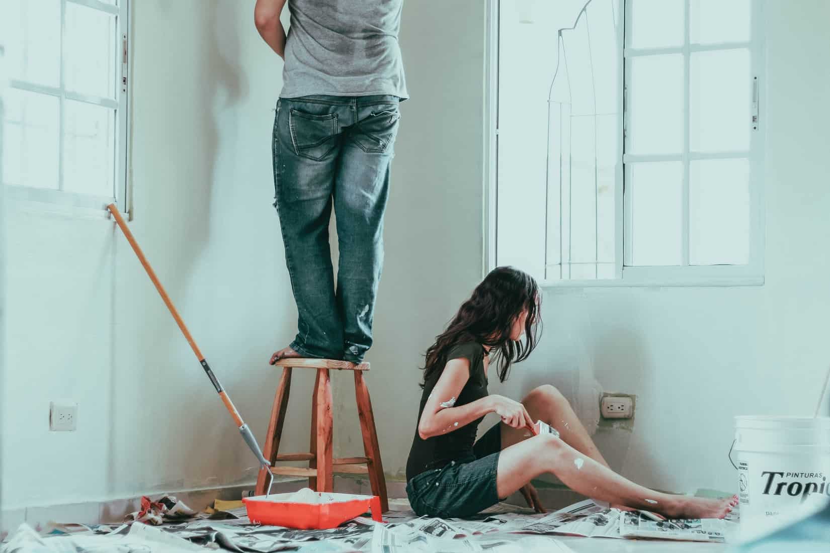 Man and woman decorating a room