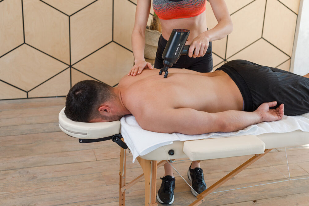 ExoGun DreamPro being used on man's back