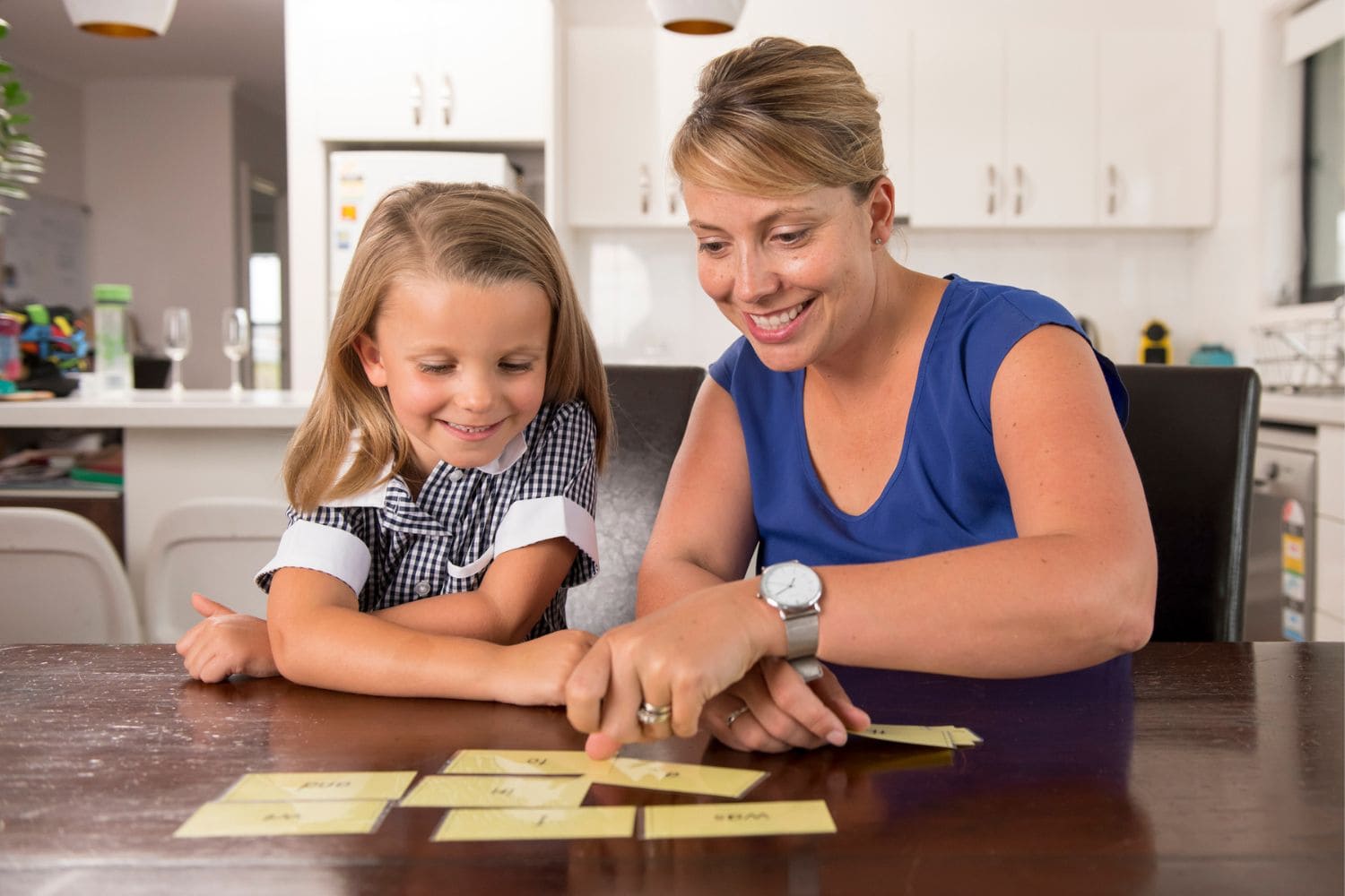 6 year old child learning with flat cards with her mother