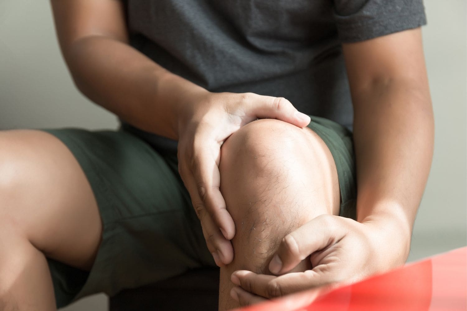 Man holding his knee, which looks to be in pain