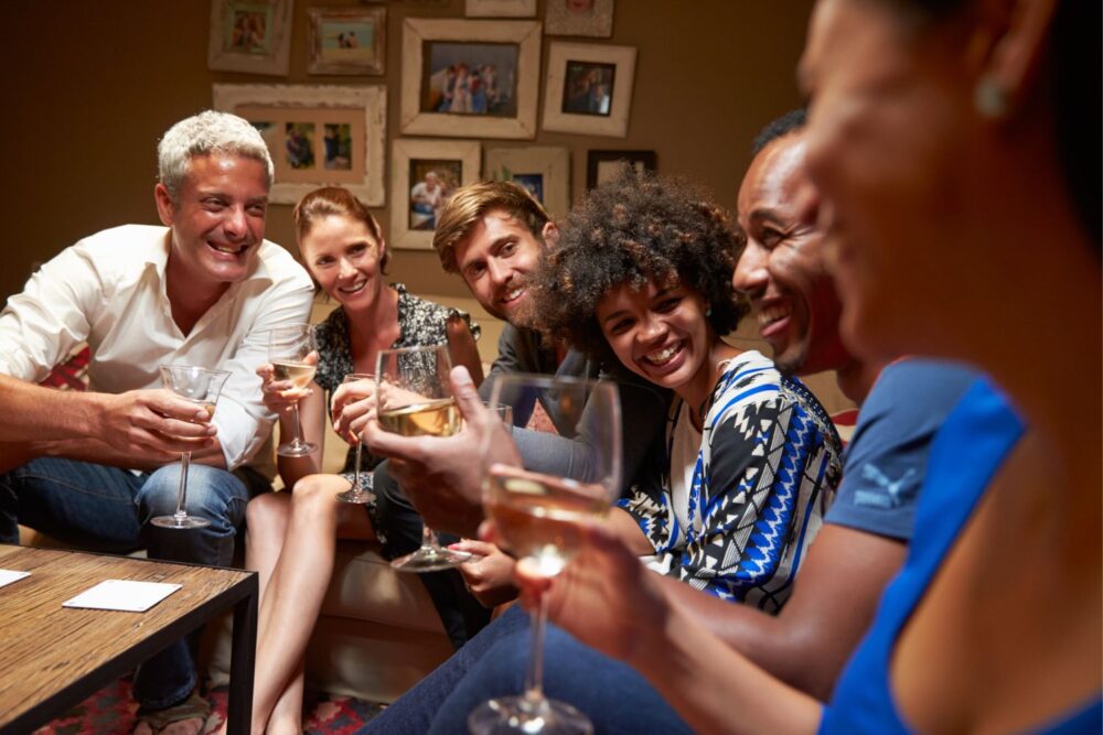 Group of friends sat around a table at a house party