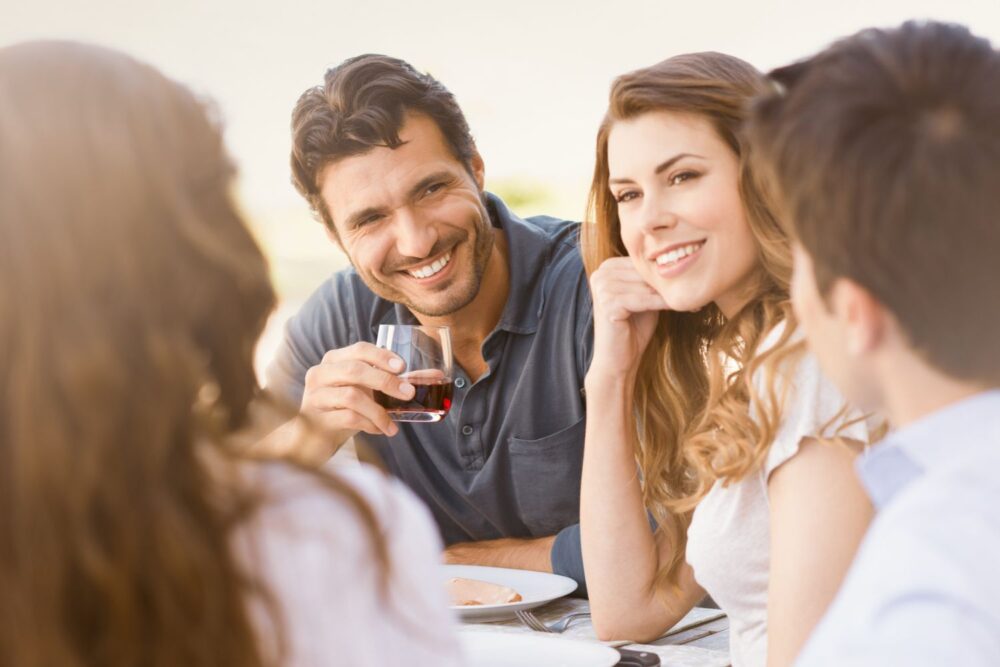 Group of friends sat around a table outside having dinner