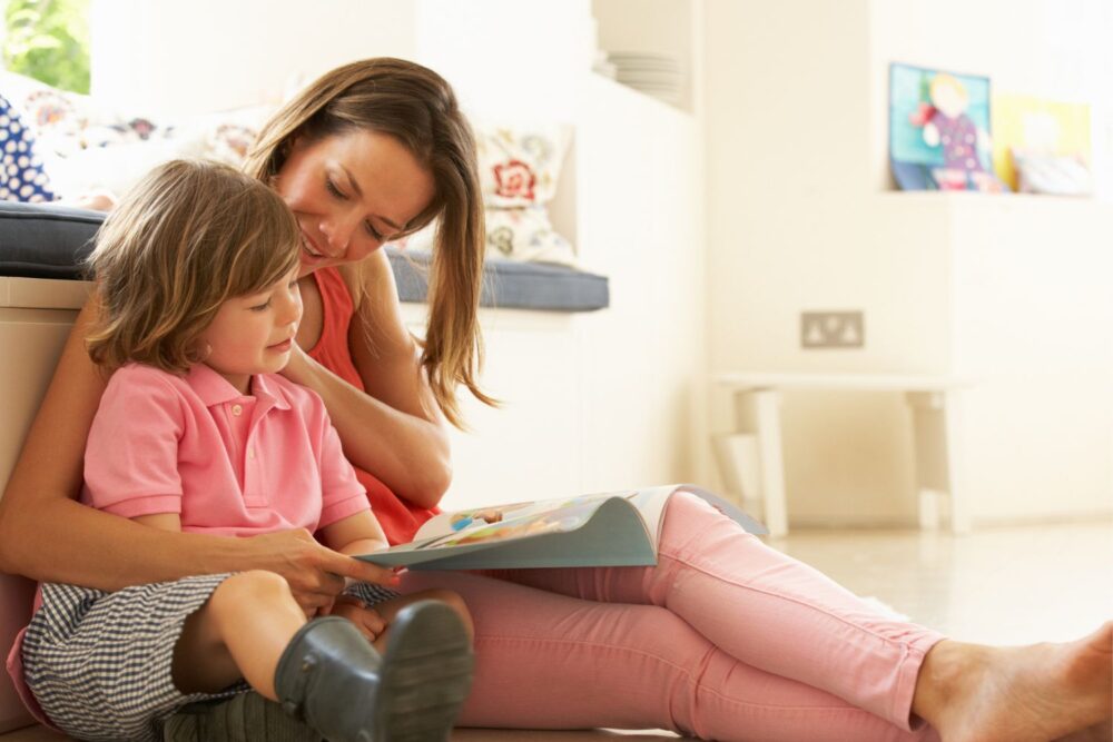 Mother reading a book indoors with her son