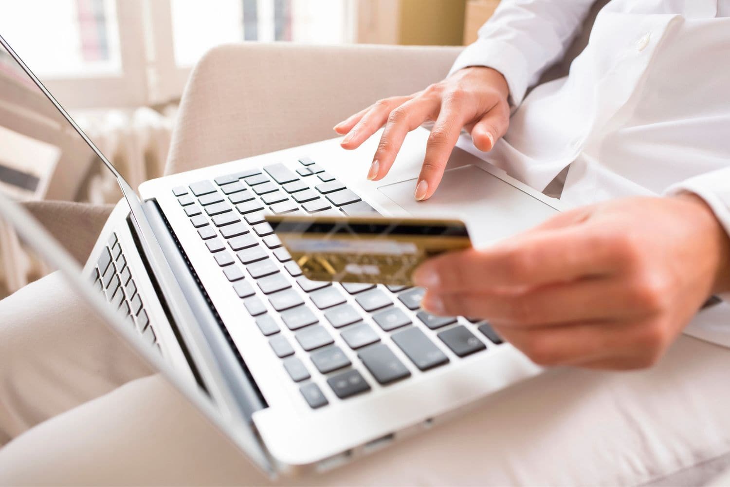 Close-up woman's hands holding a credit card and using a computer