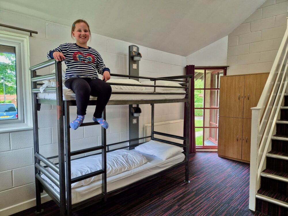 8 year old girl sat on a bunk bed at YHA York