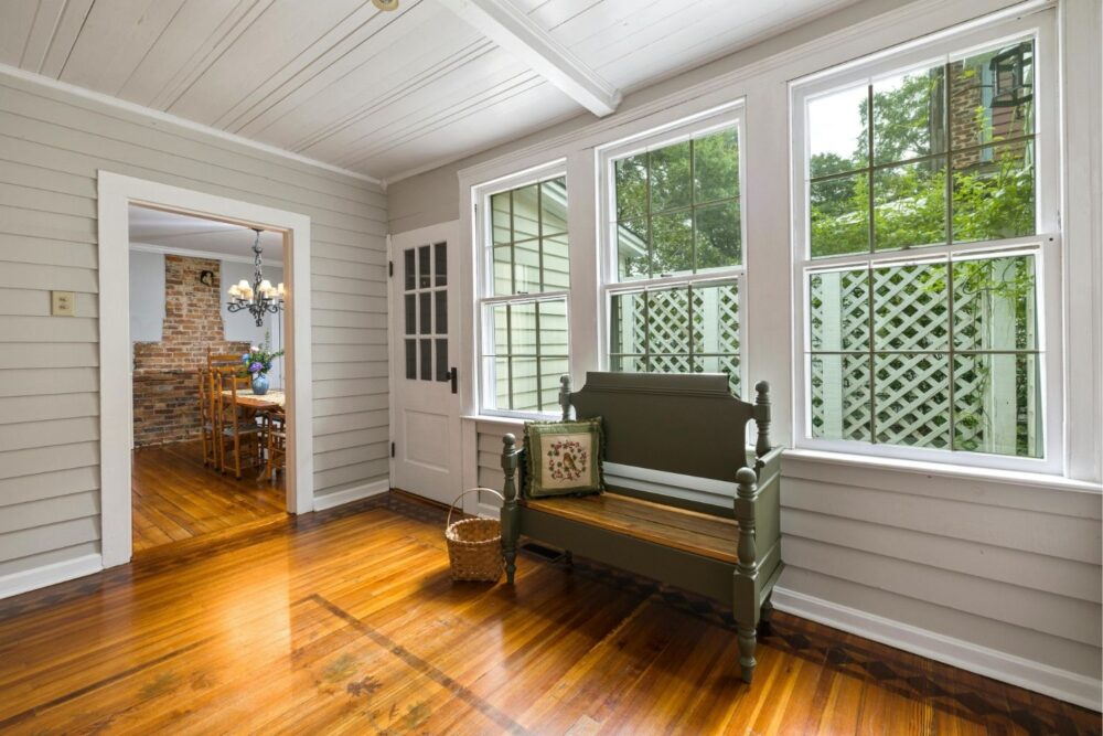 Spacious conservatory with wooden bench and large windows
