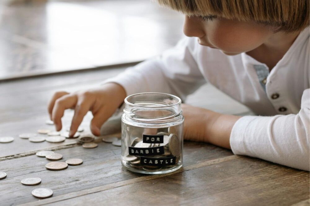 Child counting pennies from a savings pot