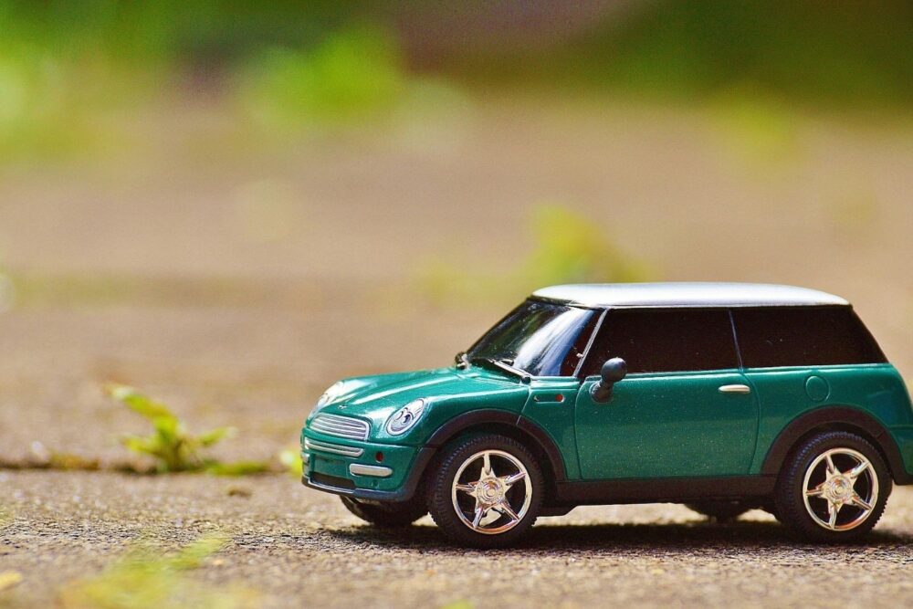 Green Scale Model Car on Brown Pavement