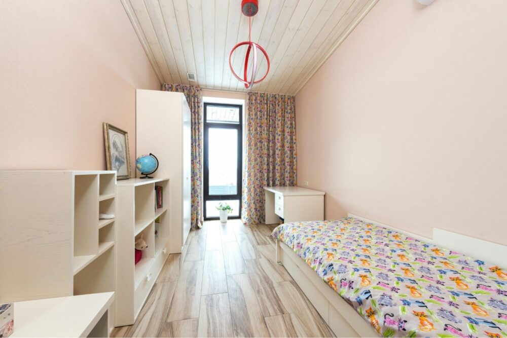 Children's bedroom with white furniture and cat themed bedding