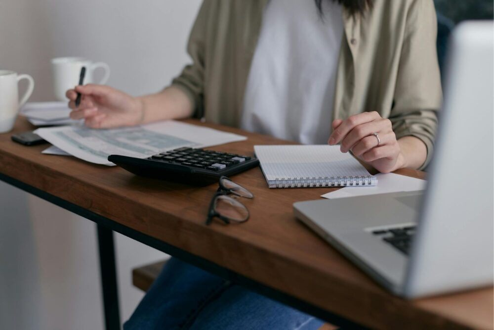 Woman sat at a desk working out finances